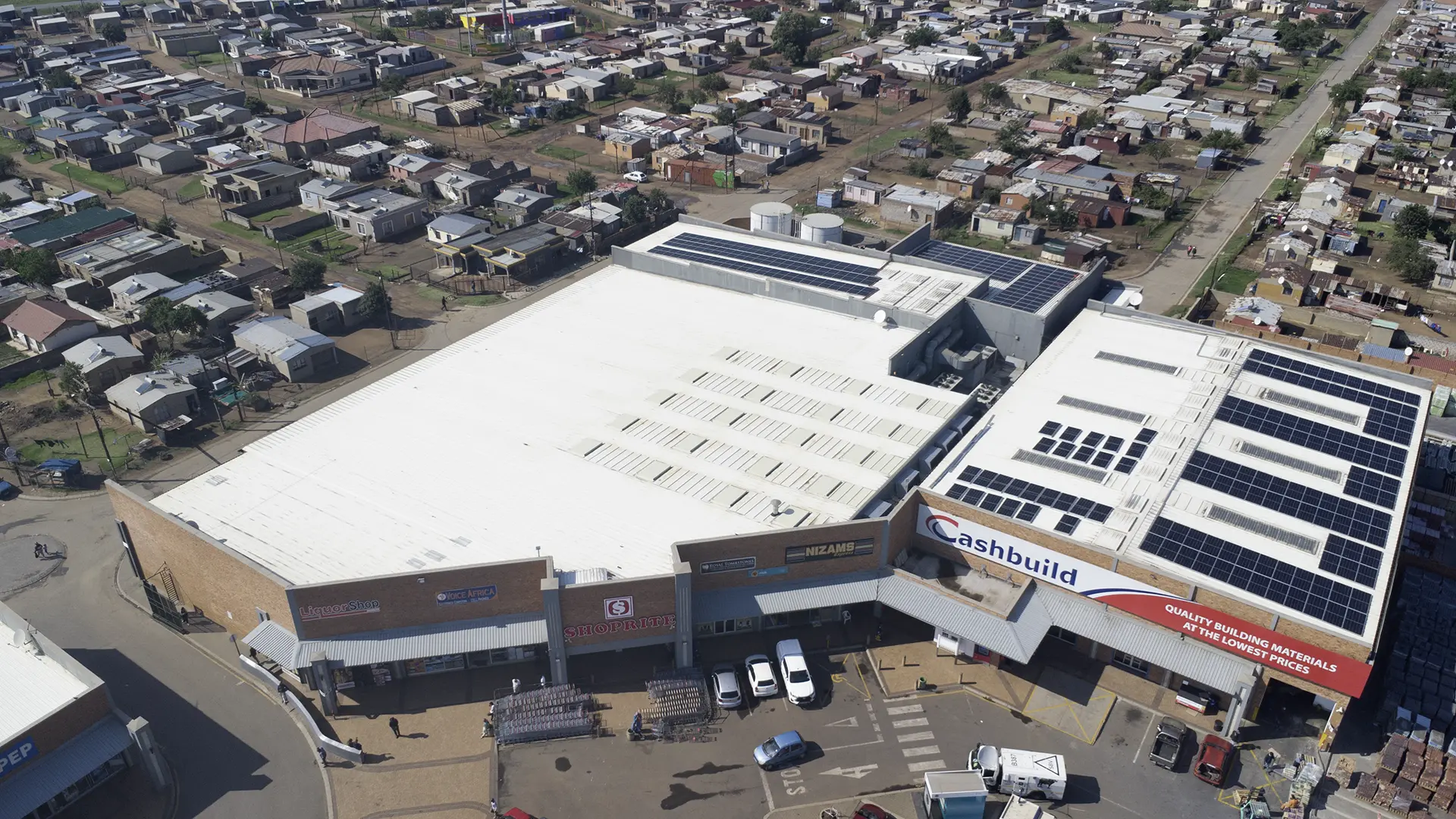 Aerial view of a sprawling industrial complex featuring multiple large grey-roofed buildings, ideal for professional roof refurbishments.